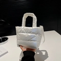 Detail view of the white quilted puffer bag texture and metallic nylon material - White