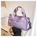 Detail of purple nylon crossbody bag with wide webbing handle and unique triangle zipper - Purple