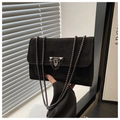 Detailansicht der schwarzen Wildledertasche mit Metallkette und geometrischem Verschluss - Schwarz
