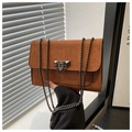 Detail der braunen Wildledertasche mit matter Oberfläche und schwarzer Metallschnalle - Braun