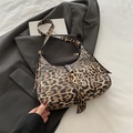 Leopard print hobo bag with gold piston closure on a stylish grey blazer background - Brown