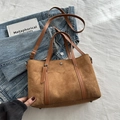 Braune Wildleder-Einkaufstasche mit Lederbesatz und abnehmbarem Gurt auf Denim-Hintergrund - Wildlederimitat / Tote Bag / Braun