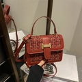 Chic red tweed crossbody bag with golden H clasp and leather handle on a reflective surface - Red