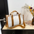 Minimalist canvas tote bag with brown straps and adjustable shoulder strap on marble top - Brown