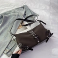 Chocolate nylon crossbody bag with retro buckle details on white textured background - Brown