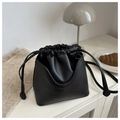 Detalle de bolso tipo cubo negro con cordón ajustable en cuero sintético de textura refinada - Negro