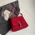 Vintage rote Tragetasche aus Wildleder mit goldener Schnalle auf grauem Blazer - Burgunderrot