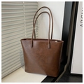 Detail of dark brown vintage faux leather tote bag with elegant shadow texture - Coffee