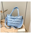 Detail of light blue quilted puffer tote bag with metallic finish and crossbody strap - Blue