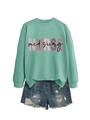 Dettaglio della felpa verde menta Nurse Med Surg abbinata a pantaloncini di denim - Felpa Verde Chiaro (Testo Nero)