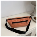 Close-up of orange nylon crossbody bag with dual black zippers and adjustable strap - Orange