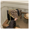 Detail of leopard print flap shoulder bag with gold chain strap and metal bar clasp - Black