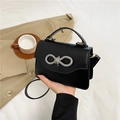 Elegant black crossbody bag with a sparkling rhinestone bow buckle and top handle - Black