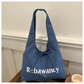 Detail der dunkelblauen Canvas-Tasche mit Schleifen-Kordelzug und weißem Rebawancy-Print - Blau