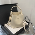 Fashionable cream bucket bag with gold hardware and a shoulder strap on a black gift box - Off White
