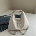 White PU leather hobo bag with silver butterfly accent and chain strap on denim jacket - White