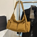 Minimalist canvas messenger bag with large front pockets and adjustable strap shown on display - Brown