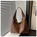 Gros plan sur la texture tressée marron d'un sac hobo chic avec des ombres naturelles douces - Café