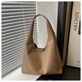 Detalle del bolso tote caqui con textura de piel de serpiente en el alféizar soleado - Caqui
