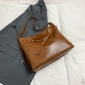 Borsa tote vintage marrone in ecopelle con fibbia in metallo su sfondo blazer grigio - Marrone