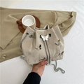 Beige bucket bag with silver butterfly charm and chain strap on stylish blazer - Light Khaki