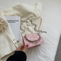 Pink mini crossbody bag with white floral pattern and silver chain on a beige blazer - Pink