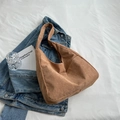 Bolso tote de pana marrón con correa ancha sobre una cama blanca minimalista - Caqui