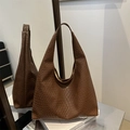 Braune gewebte Hobo-Tragetasche aus Kunstleder im eleganten Stil auf Buchständer - Braun