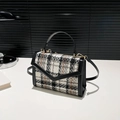 Chique zwart-witte tweed crossbodytas met oranje accenten en een gouden ringsluiting - Grijs