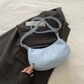 Bolso de media luna azul claro en cuero sintético sobre una americana negra - Azul