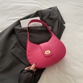 Sac hobo croissant rose vif avec fermoir doré sur fond de veste de costume grise - rose vif
