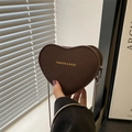 Borsa a tracolla a cuore marrone scuro con catena e logo dorato in luce soffusa - Marrone