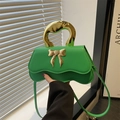 Modern green leather handbag with gold bow ornament and metallic top handle - Green