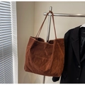 Detail of caramel brown suede tote bag featuring a functional front pocket and slim strap - Coffee