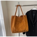 Detail of caramel brown suede tote bag featuring a practical rectangular front pocket - Brown