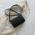 Minimalist black quilted crossbody bag with triangle stitching and silver hardware - Black