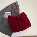 Deep red velvet tote bag with exterior pocket on grey suit background - Burgundy