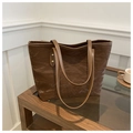 Detail of dark brown tote bag featuring unique pleated texture and gold metallic rivets - Brown