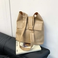 Beige PU-Leder Tragetasche mit breitem Schultergurt und Frontklappentasche auf Sofa - Sandfarben