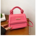 Hot pink handbag with knotted handle and gold metal detail on a wooden table - Rose Red