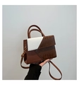 Detalle del bolso bandolera con cuero de cocodrilo marrón y herrajes metálicos dorados - Marrón