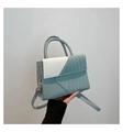 Detalle de bolso bicolor con textura de cocodrilo y herrajes dorados elegantes - Azul