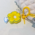 Close-up of a plush flower bag charm with a yellow silicone strap and metal carabiner - Flower Charm