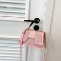 Pink faux leather handbag with silver rhinestones and gold hardware hanging on a door - Pink