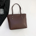Dunkelbraune Shopper-Tasche mit Krokodilleder-Prägung und goldenen Nieten auf weißem Grund - Dunkelbraun