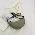 Olive green nylon half-moon crossbody bag with adjustable strap on a beige blazer - Green