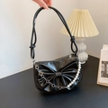 Chic black bow shoulder bag with pearl chain and glossy finish in a lifestyle setting - Black
