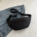 Zwarte fannypack met wafeltextuur en verstelbare riem op een denim jack achtergrond - Zwart