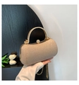 Makro-Detail der champagnerfarbenen Glitzer-Abendtasche mit Perlenverschluss und Metallgriff - Gold