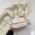 Chic beige quilted crossbody bag with adjustable strap and plush charm on white blazer - Off White